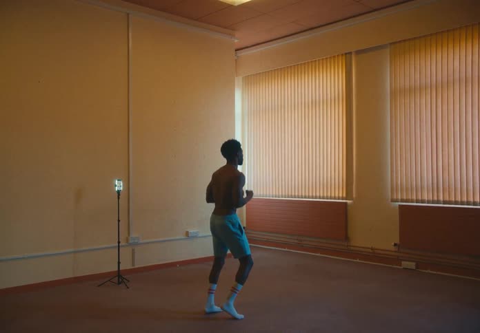 Shirtless young man working out inside a room