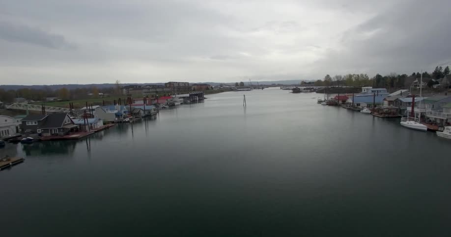 Moving across a pier with houses and boats near the water