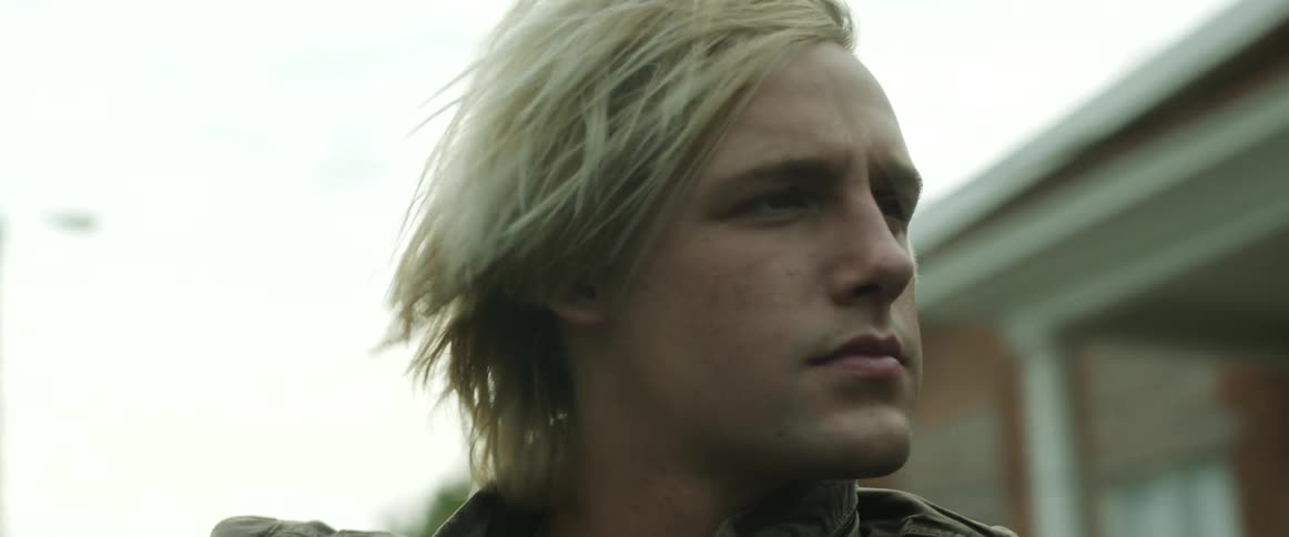 Young blonde man riding passenger seat on a convertible car