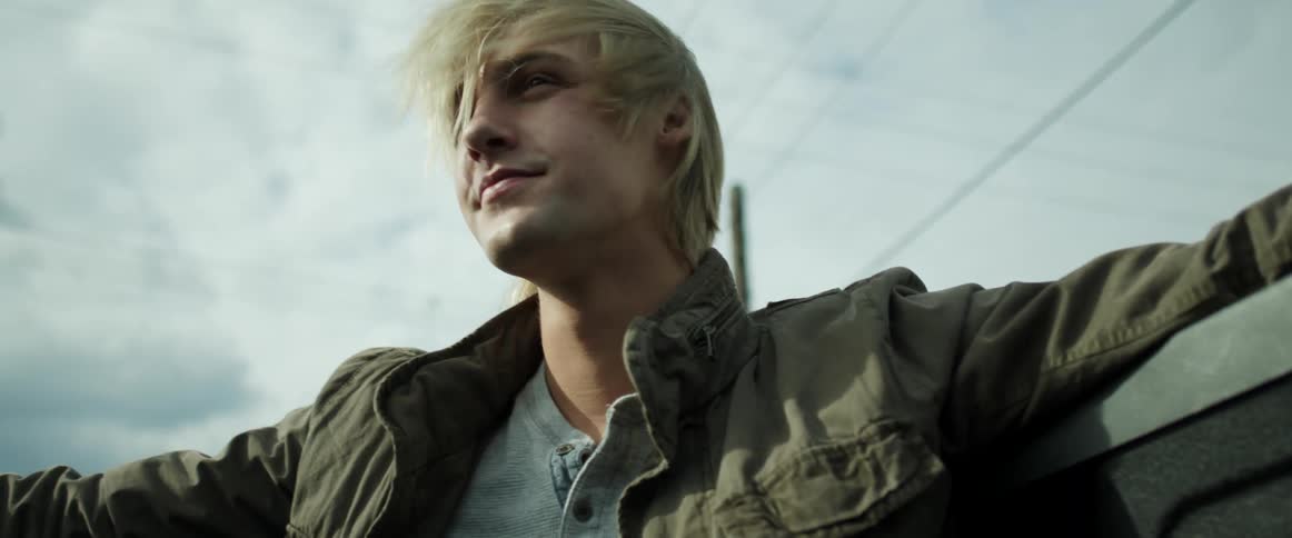 Wind blows through a young mans hair as he rides in the cab of a pickup truck