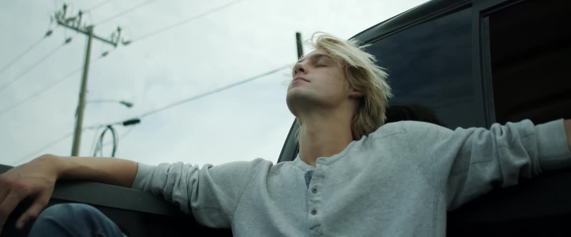 A man is sitting in the back of a moving truck