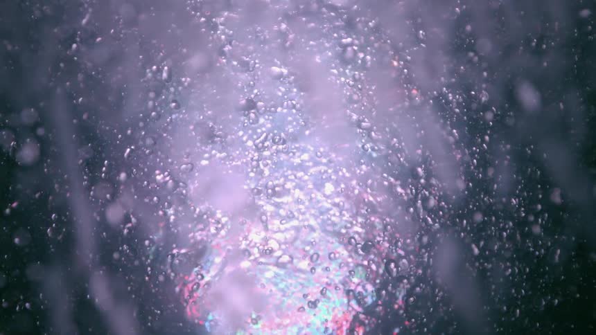 Water splashing against the surface with lights flashing in a reflection
