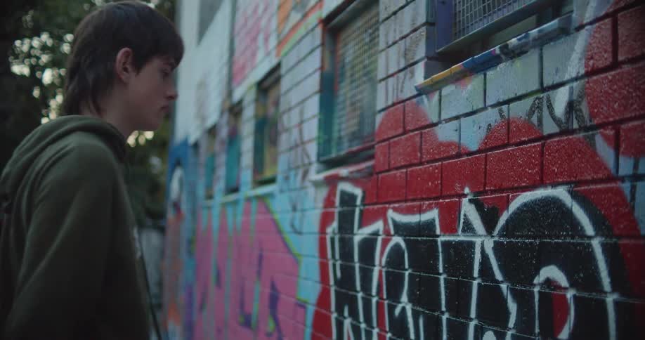 A teenager is spraying a design on the building