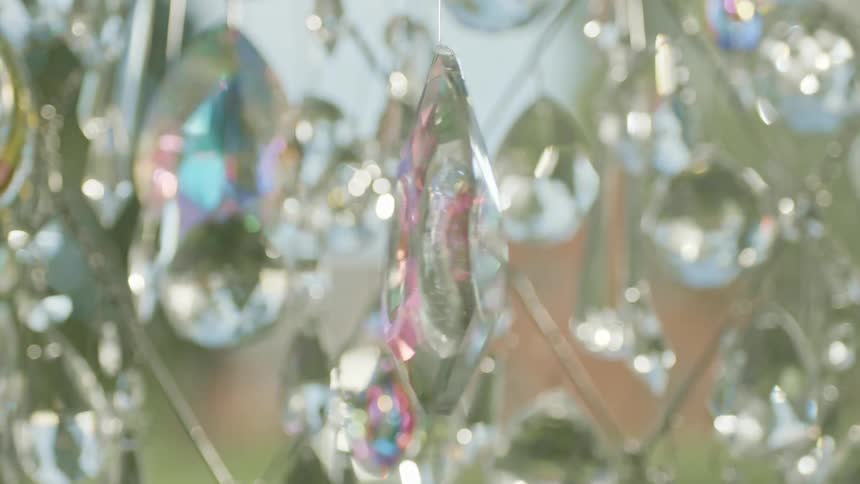 A jewel ornament hanging in front of window spins around