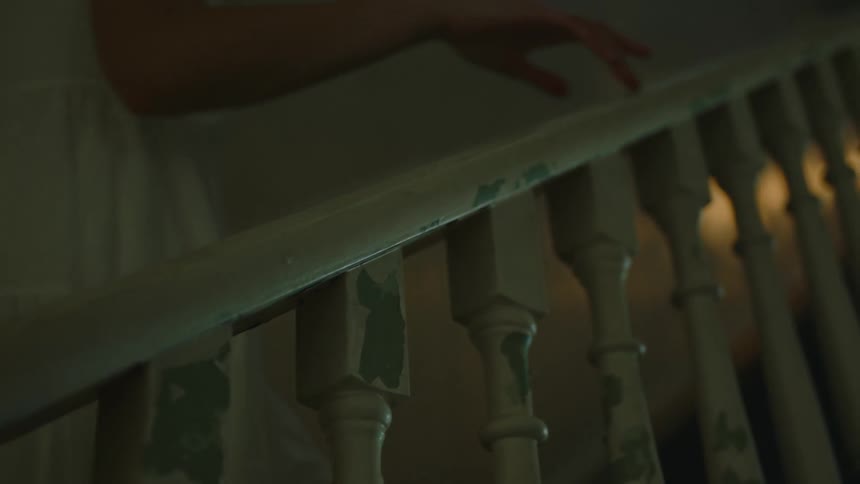 Woman holds hand rail as she climbs steps