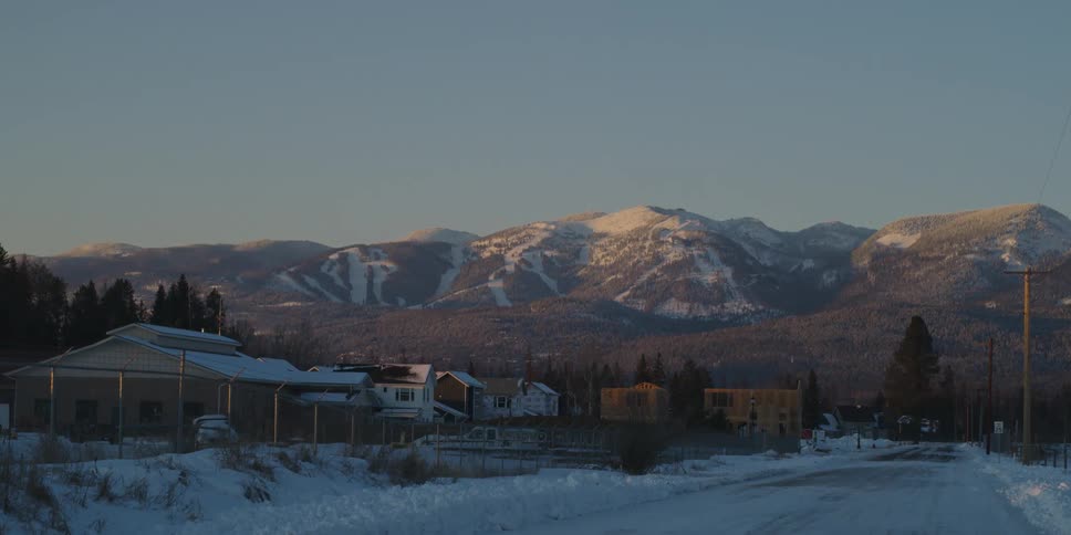 Small town near the snow covered peaks of a mountain range at morning