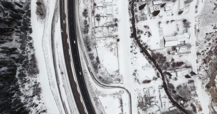 Aerial view of a town with a road covered in snow