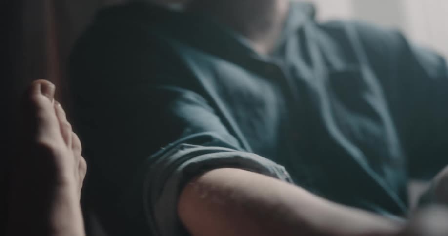 Man holdsand tickles another persons foot until they pull it away