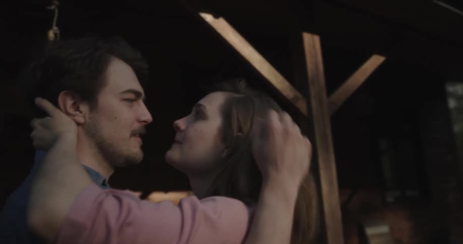 A woman runs out of a house and into the embrace of a man who spins around with her in his arms before they share a kiss