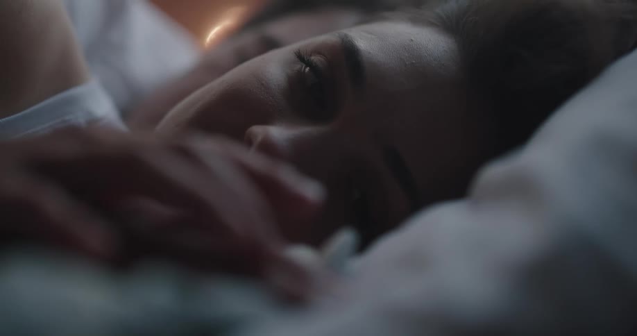 A man and woman laying together in a bed