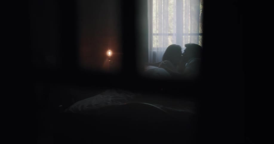A man and woman laying in a bed kissing