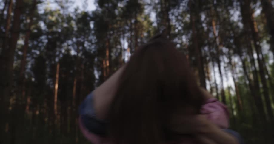Couple hug laugh run and play in field near woods