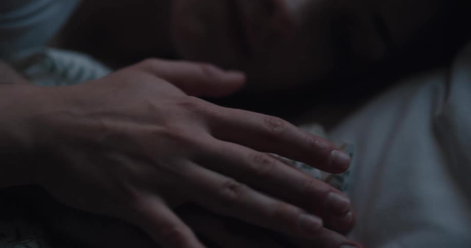 Close up of the faces of a young couple sleeping in a bed