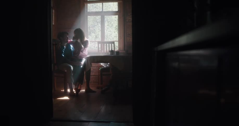 A husband and wife kissing on a chair