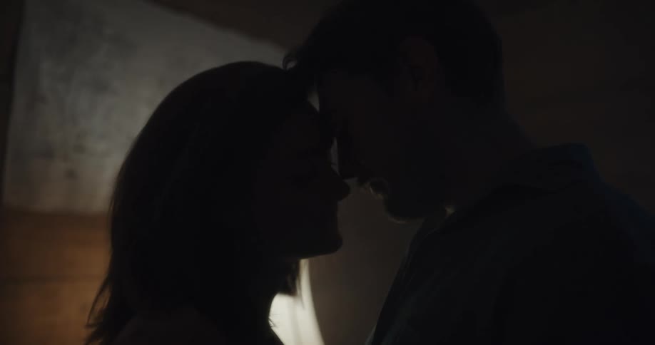 A man and woman hugging each other and nearly kissing