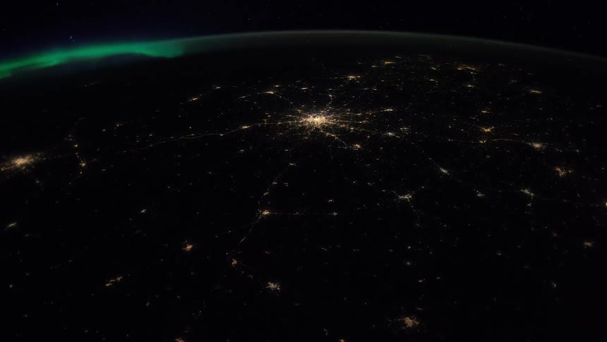 Lights from cities shine on globe at night under atmosphere