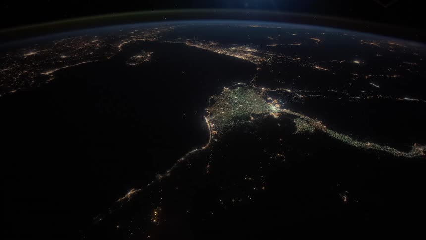 City lights twinkle at night from the surface of earth