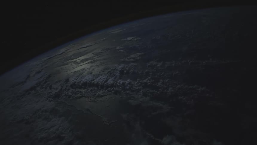 White of clouds contrast with grays of surface with space showing over curvature of horizon
