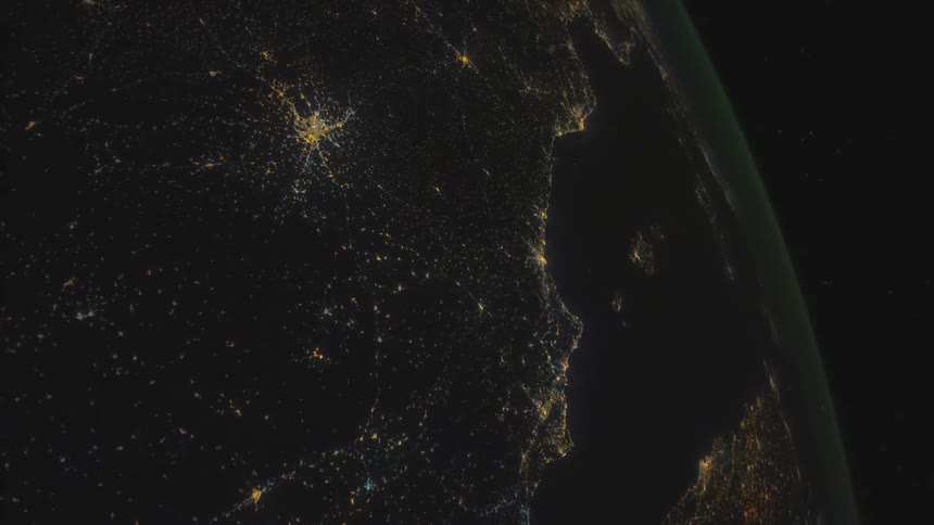 Earth lights outline shore at night