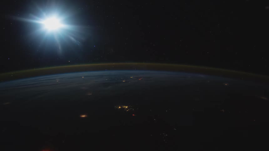 The sun glows and shine above the curve of earth in space