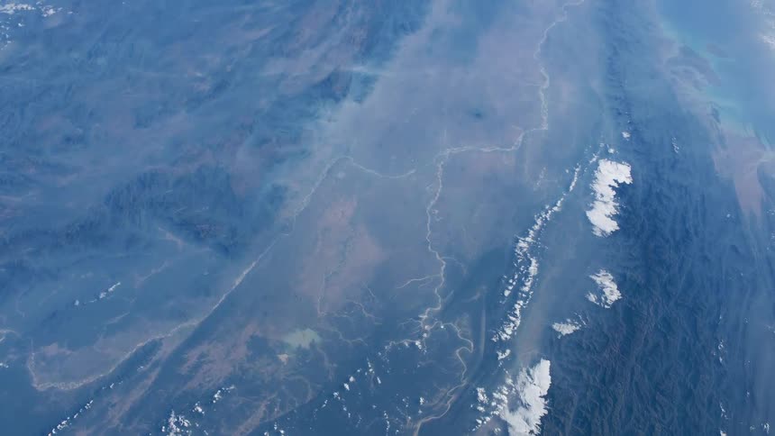Clouds over mountans and deserts on the earth landscape seen from space