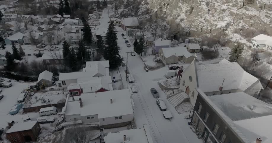 A snow covered city near a snowy mountain