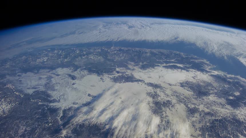 The curved surface of blue and white earth against the black of outer space