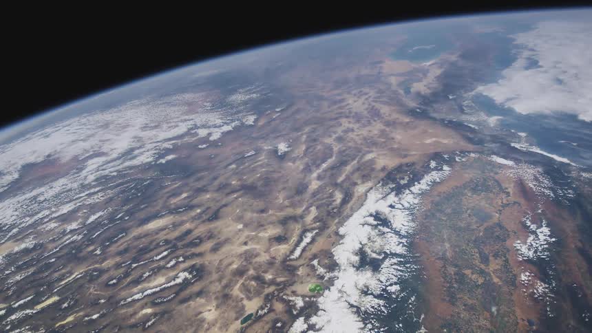 Snow covers mountain ranges bordering land contrasting with oceans