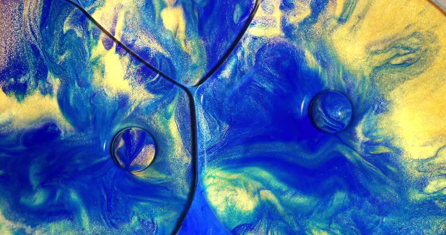 Bubbles in a blue and yellow liquid expanding