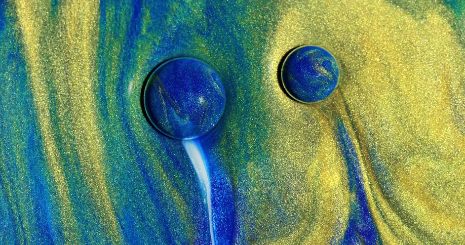 Blue bubbles flow then merge in a sea of yellow and blue glitter