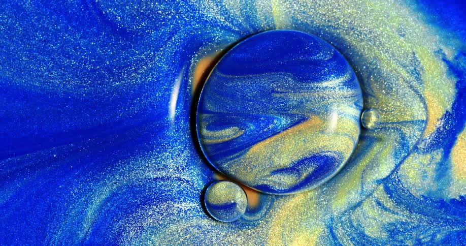 A viscous blue light with yellow flecks forming a bubble and expanding