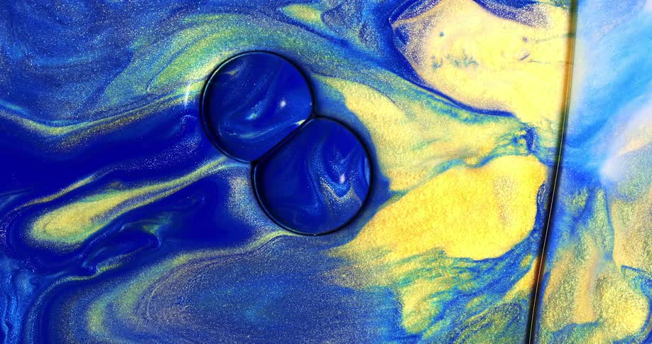Spheres of blue liquid roll through blue and gold liquid