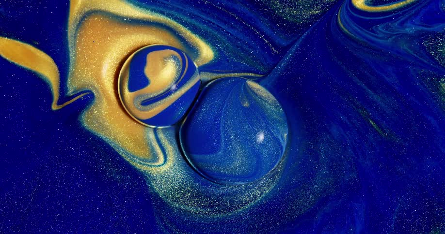 Blue and gold liquid rises up to form spheres