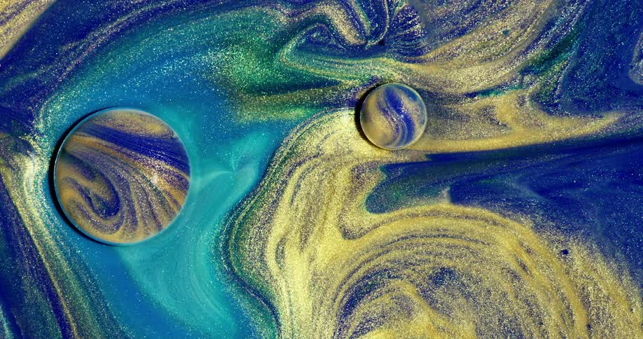 A multicolored liquid with glitter mixed into it is splashed and perturbed