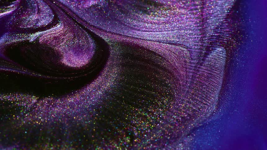 A purple hued glittery fluid flows outwardly and mixes around