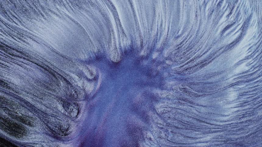 A grainy blue liquid flowing from the center towards the edges
