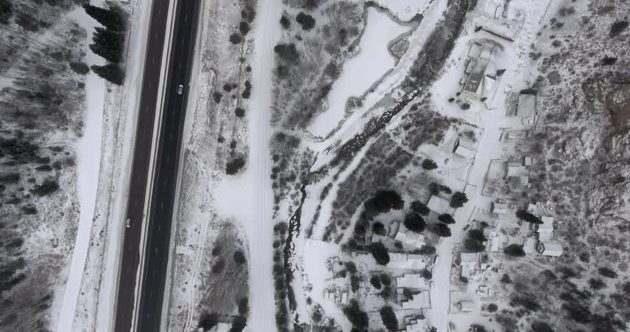 Two vehicles travelling along a road in the winter