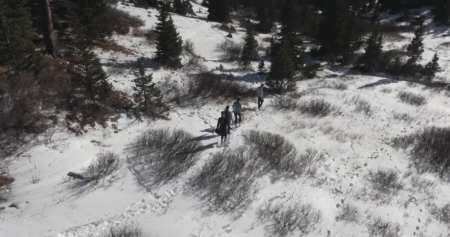 Aerial view of people hiking over a snow covered field