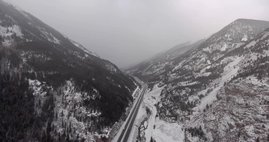 A road between two snow covered mountains on a winter day