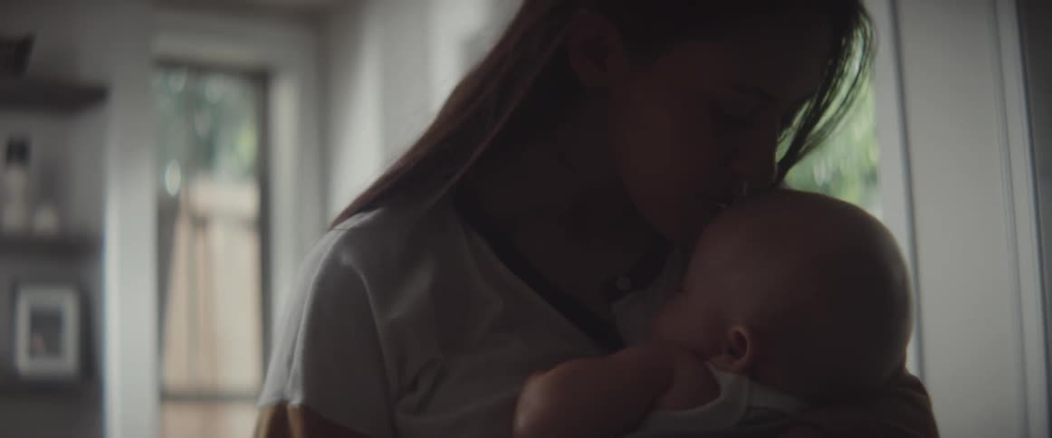 A mother holding a baby in a room