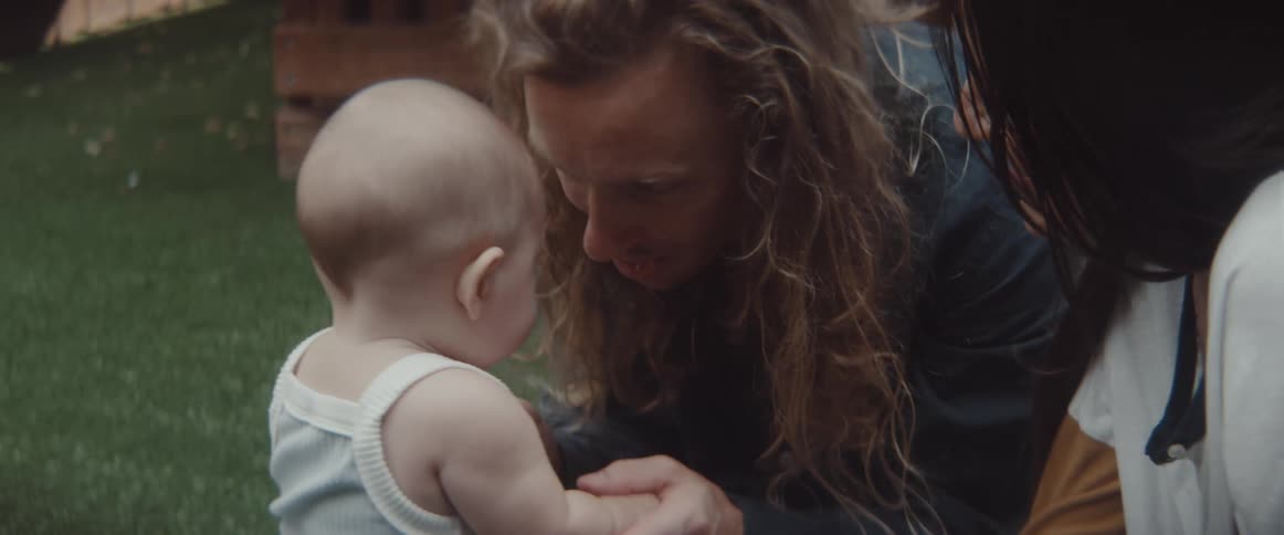 A mother and father playing with a baby