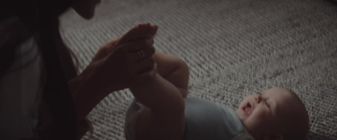 A mother is playing with her baby on the floor