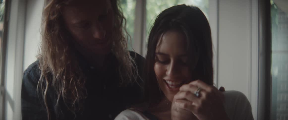 Young couple cuddling their baby at home in the morning