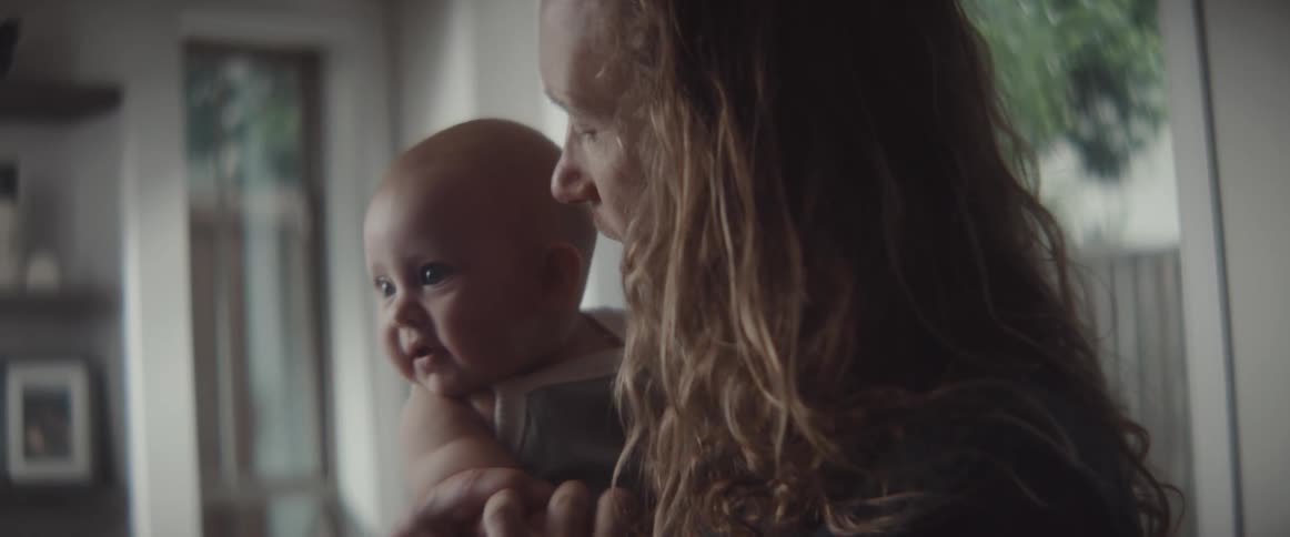 A dad kisses and smiles as he holds and sways with his happy baby