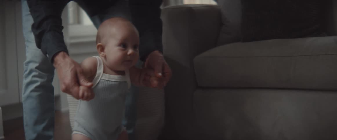 Father playing with his infant son in the living room at home