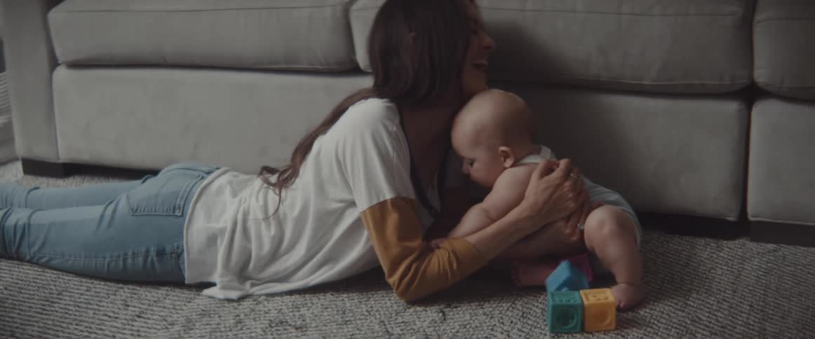 A mother and son play around on the carpet