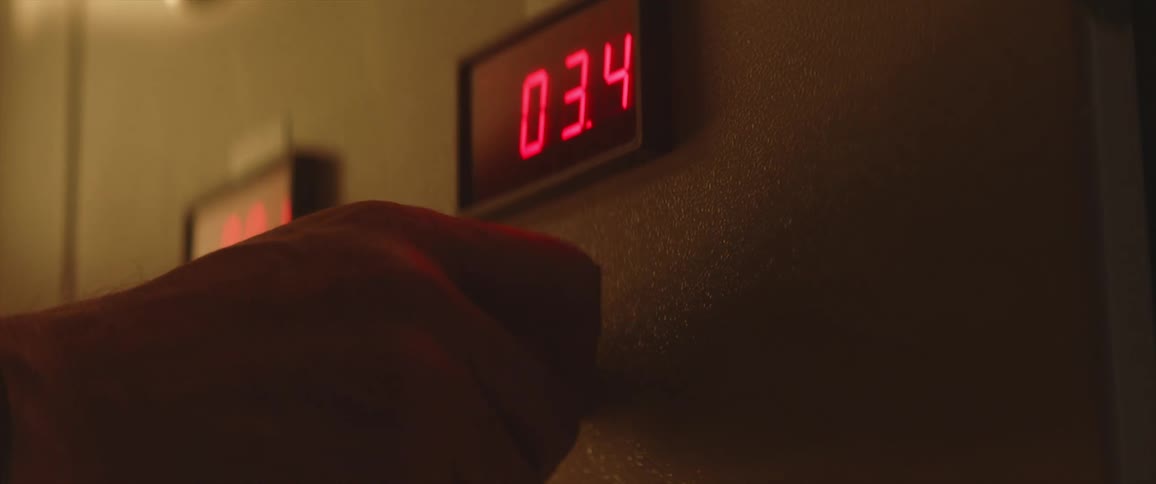 A hand turns a knob increasing numbers on a digital display