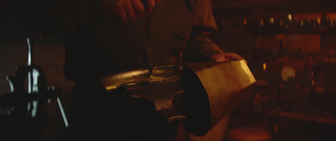 A metalworker uses a hammer to beat a slab of metal