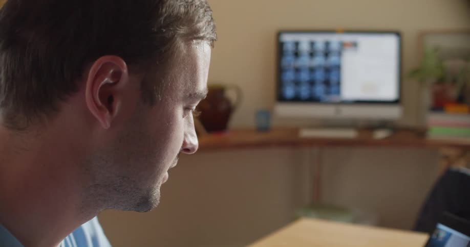 A nurse participates in a video chat on a laptop while sitting at a desk