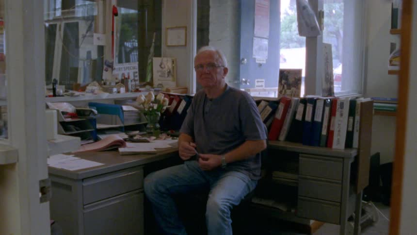 A portrait of a man sitting at a desk
